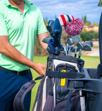 Golf cart bag holder securing golf clubs on a cart